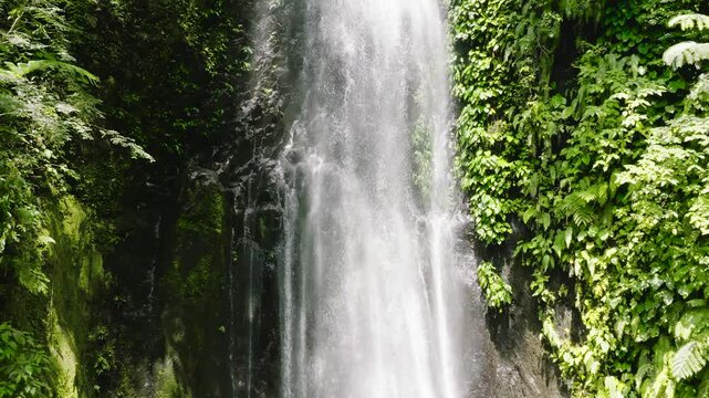 Top view of waterfall in green forest in slow motion. Pulang-Tubig Falls in mountain jungle. Negros, Philippines.