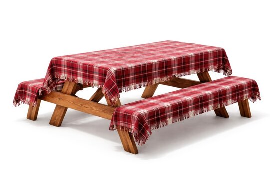 Outdoor style wooden picnic table with benches draped in red plaid fabric on white background