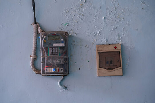 Vintage payphone and electrical outlet on a blue wall