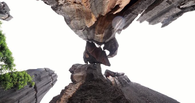 Nadir shot captures thrilling, vertigo-inducing perspective of famous 'Close Call' (Geng Xian) formation, huge stone stuck between two peaks at Shilin Stone Forest. Spinning camera movement