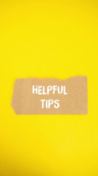 Animated helpful tips message on torn paper. Stop motion typography revealing assistance, advice, and support concepts on a bright and minimalist yellow background