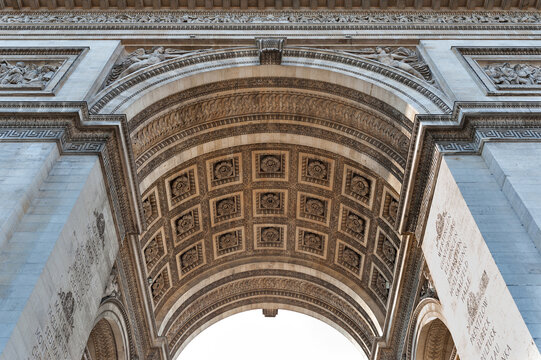 View of the intricate stone carvings and coffered ceiling under the arch of the Arc de Triomphe in Paris, Ile-de-France, France.