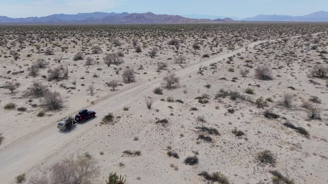 SUV tows a teardrop camper trailer across the Baja desert close to the El Salar salt flats in Baja California