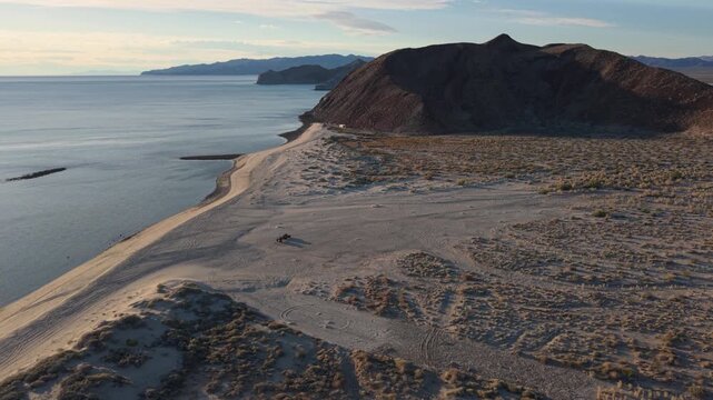 Aerial view of a teardrop camper trailer at sunrise while dispersed camping on the beach near Papa Fernandez in Baja California Mexico