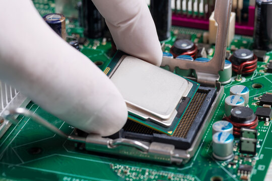 Technician Installing CPU Processor Into Motherboard Socket During Desktop Computer Hardware Upgrade