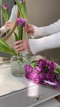 Female Hands Arranging Purple Lily Flowers into Vase with Elegant Floral Aesthetic