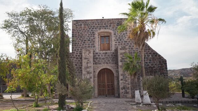 Explore Mission Church Santa Rosalia in Mulege Baja California Sur Mexico with palm trees and desert mountains around the site.