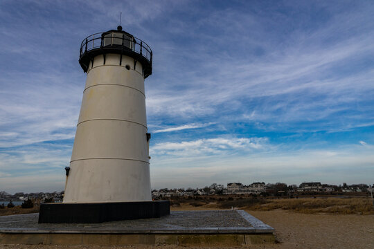 View of the historic Edgartown Harbor Light on Martha's Vineyard with its white tower and stone base under a blue sky Edgartown, Massachusetts, United States.