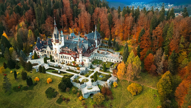 Peles castle surrounded by autumn forest in carpathian mountains