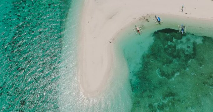 Sandbar with boats and with waves. Transparent turquoise water. Mantigue Island. Camiguin, Philippines.