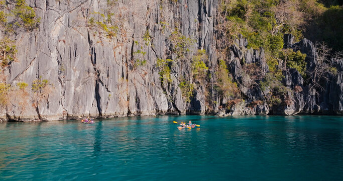 Kayaking in turquoise lagoon water near limestone cliffs