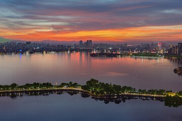 Twilight panorama of West Lake in Hanoi with colorful sunset clouds, calm reflections, and illuminated Thanh Nien Road waterfront scenery. © Hanoi Photography