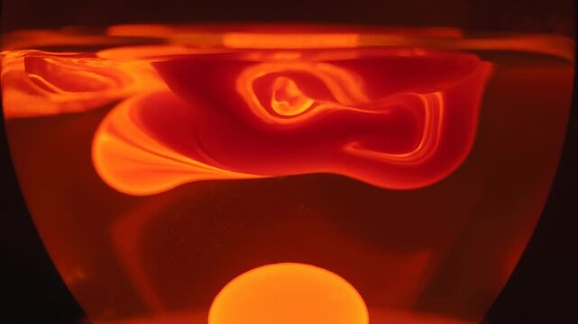 Abstract glowing red vortex swirl with fluid motion and vibrant orange light patterns in dark background