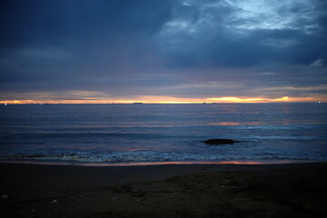 Obraz premium Coastal Sunset Under Heavy Clouds