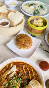High angle view of Malaysian breakfast Sarawak laksa, toasted bread, shumai kopitiam
