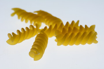 Naklejka premium uncooked fusilli pasta isolated showing detailed spiral texture and warm golden color