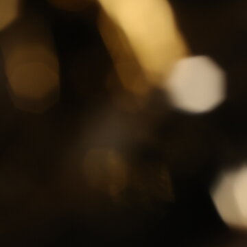 Gold bokeh lights abstract background with dark overlay