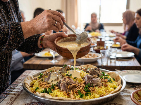 Jameed sauce being poured over traditional mansaf rice and lamb dish