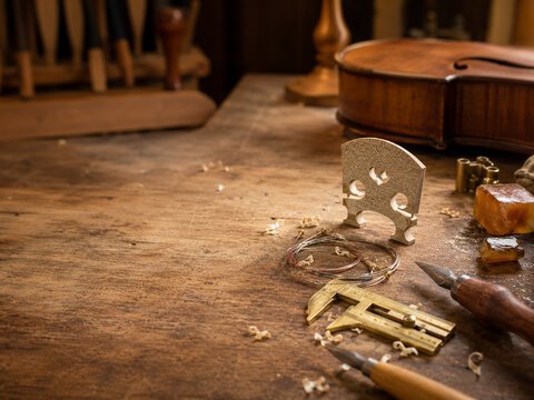 Luthier workbench with violin bridge and brass calipers