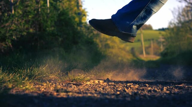 Feet kicking up dust on road
