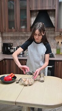 Woman seasoning fresh mushrooms in glass bowl at home kitchen vertical video