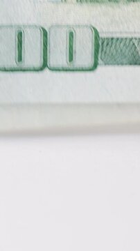 Closeup hundred dollar bill edge tapping, crisp macro view of numeral and paper texture, rhythmic edge tapping motion suggesting careful counting and verification, visible green