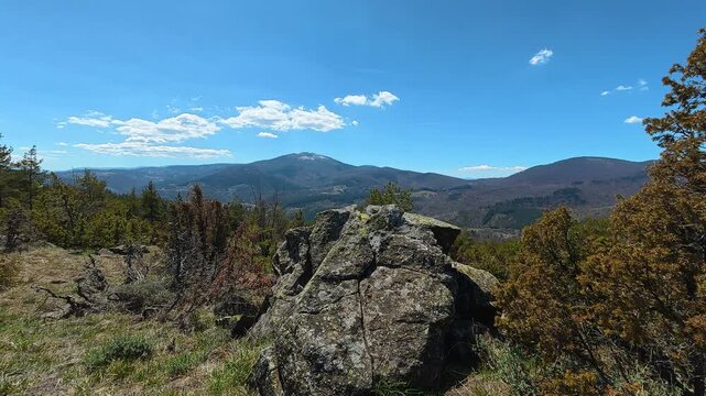 Blue sky above rugged rock and distant mountains. Mount Goc, Ljukten peak. Balkans, Serbia