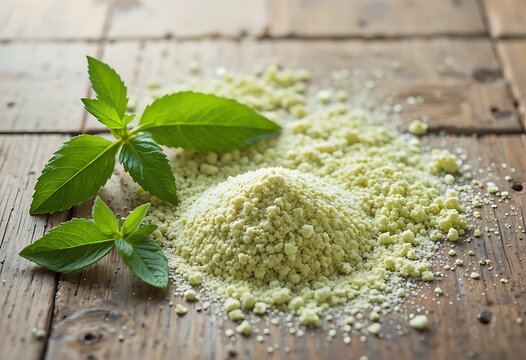 A pile of green matcha tea powder with fresh mint leaves on a rustic dark wooden table surface. stevia powder