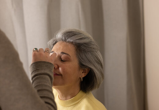 Senior woman receiving professional makeup application service