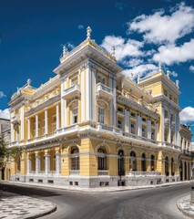 Obraz premium Ornate yellow building with classical architecture and balconies on a sunny day