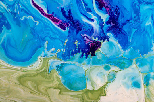 Bright colors mix in unusual patterns on a canvas in a studio during daytime hours