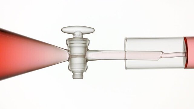 Reddish transparent liquid flows from separatory funnel through glass stopcock into test tube, filling it on bright white bg | Cranberry liquid extract beauty product formulation concept