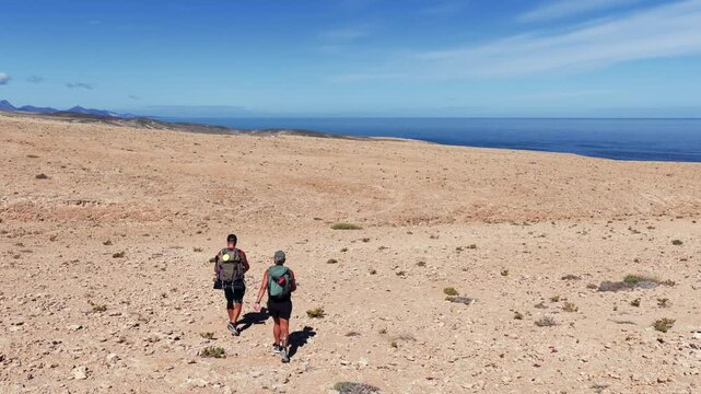 Aerial View of Hikers Trekking Across the Arid Desert Dunes of the Isthmus of La Pared, Fuerteventura