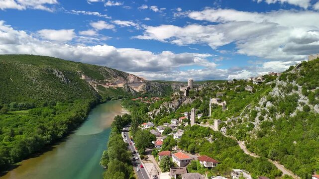 Aerial view of the medieval village Počitelj in southern Bosnia and Herzegovina. It shows the stone fortress. Narrow streets run through the village. The Neretva River flows through the valley.	