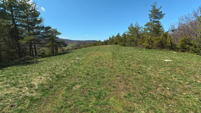 Green hill slopes gently under bright blue sky. Mount Goc, Ljukten peak. Balkans, Serbia