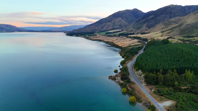 Aerial drone view of Lake Tekapo at sunset, with dramatic alpine scenery in New Zealand.Panoramic landscape of the South Island. A scenic road near the Lake Tekapo region, a popular travel destination