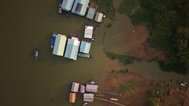 Top-down aerial of floating houses and muddy riverbank, Chau Doc, Vietnam