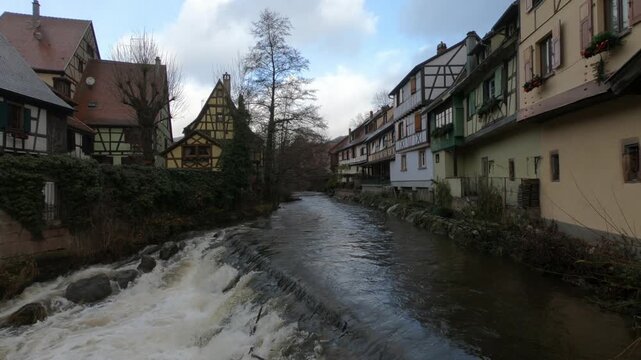 The Weiss river running between half timbered houses, Kaysersberg, Alsace, France, Europe. River with strong current flowing through the rocks.