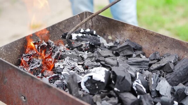 Setting up a grill with charcoal for cooking outdoor meals