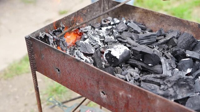 Starting a grill with charcoal and fire in the outdoor area
