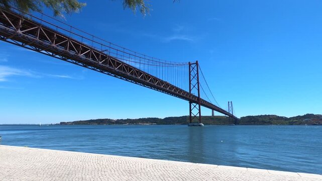 Christ-King and the 25 April Bridge (Ponte 25 de Abril), a steel suspension bridge located in Lisbon, Portugal, crossing the Tagus River (Rio Tejo).