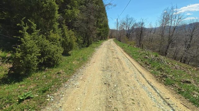 Sunlit dirt path winds through green hills. Mount Goc, Ljukten peak. Balkans, Serbia