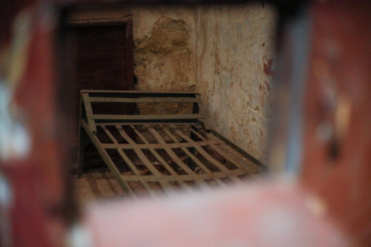 a worn metal prison bed displayed in a museum of Soviet repression stands as a silent reminder of detainees suffering and political imprisonment within NKVD and KGB detention facilities history