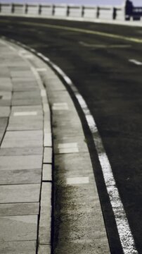 A winding road leads into the distance, with muted colors filling the evening sky. The smooth pavement glistens softly as shadows play along its edges, inviting exploration and wonder.