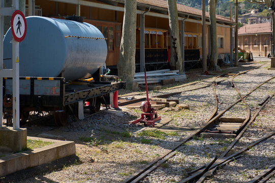 Vintage industrial railroad turnout switch control system on the ballast ground of a historic train line station.