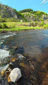 Clear river flows past mossy rocks. Bigar Waterfall, Serbia. Vertical