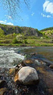 Clear river rushes over smooth stones. Bigar Waterfall, Serbia. Vertical