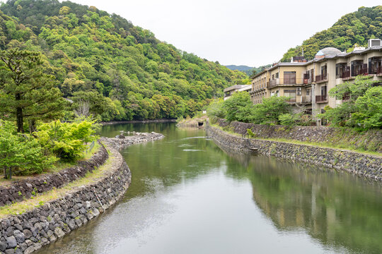Calm Uji river in Uji Japan (Kyoto Prefecture) on an overcast spring day, lots of greenery and trees