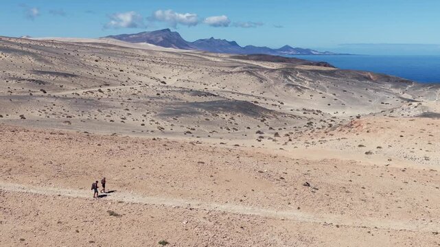 Aerial View of Hikers Trekking Across the Arid Desert Dunes of the Isthmus of La Pared, Fuerteventura