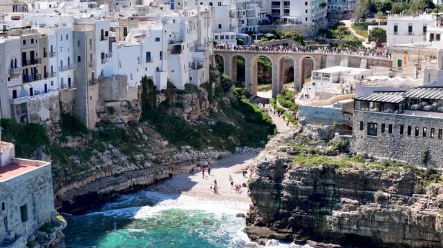Polignano a Mare with Lama Monachile beach. Aerial 4K drone video footage with panorama view of stunning coastal townscape in Puglia, southern Italy